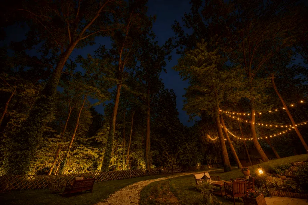 Parc arboré du Domaine du Moulin Bicheret illuminé de guirlandes lumineuses à la nuit tombée