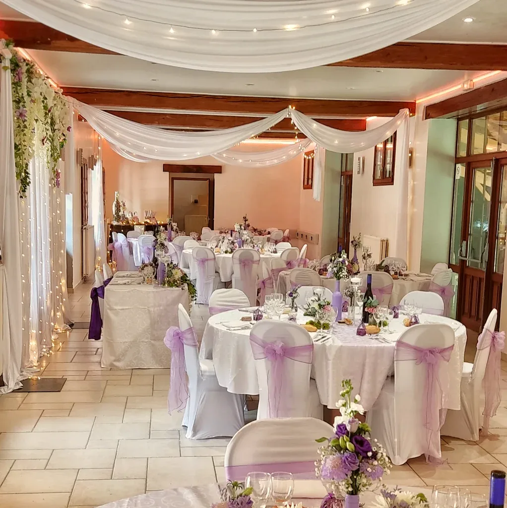 Salle de réception du Moulin Bicheret décorée en lilas et blanc avec voilages et guirlandes